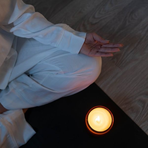 A serene setting with yoga mat, candles, and soft lighting.