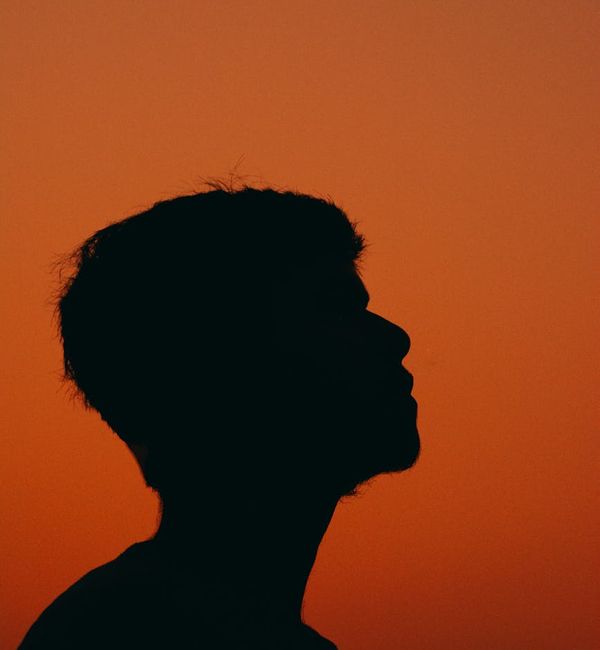 Silhouette of a person meditating against a dark, peaceful background.